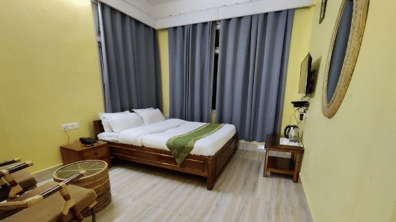 A double bed room with windows, curtains and tables