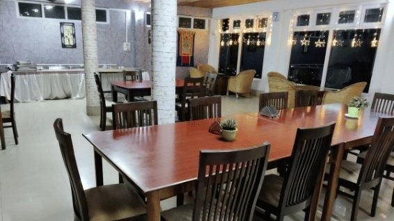 A restaurant seating area with table and chairs, lights set for diners