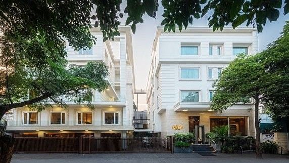 The exterior facade of Hotel Saket 27, New Delhi, building surrounded by greenery.