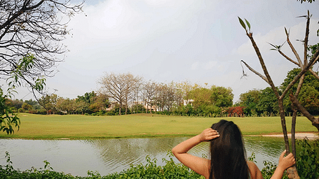 A person standing by a lake with trees in the background, photographed at Karma Chalets.