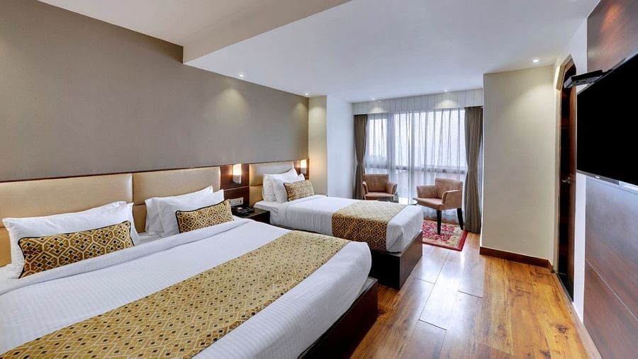 A large double bed and a single bed in the Premium Triple Room at Hotel Sumitel Vista T.V Tower 
