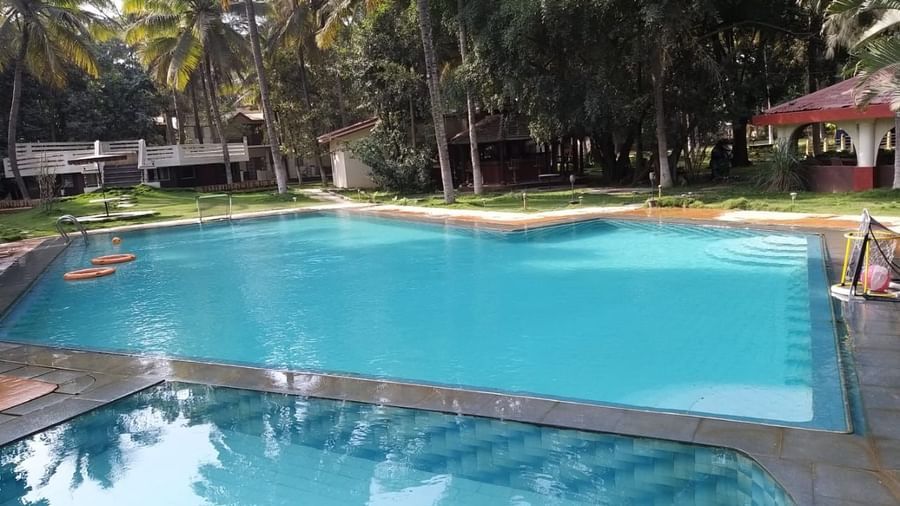 Outdoor swimming pool surrounded by palm trees at Fantasy Golf Resort.