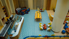 Overhead shot of a colourful cafe in Hargeisa with blue sofas and round tables - Serene Sarovar Premiere Hargeisa