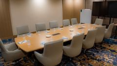 A compact meeting room in Hargeisa with chairs, a long table, and a projector - Serene Sarovar Premiere Hargeisa