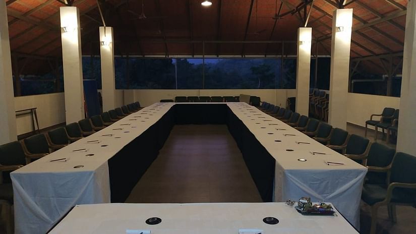 A long meeting table is set with chairs in a room, ready for a meeting. - Abad Brookside Lakkidi, Wayanad