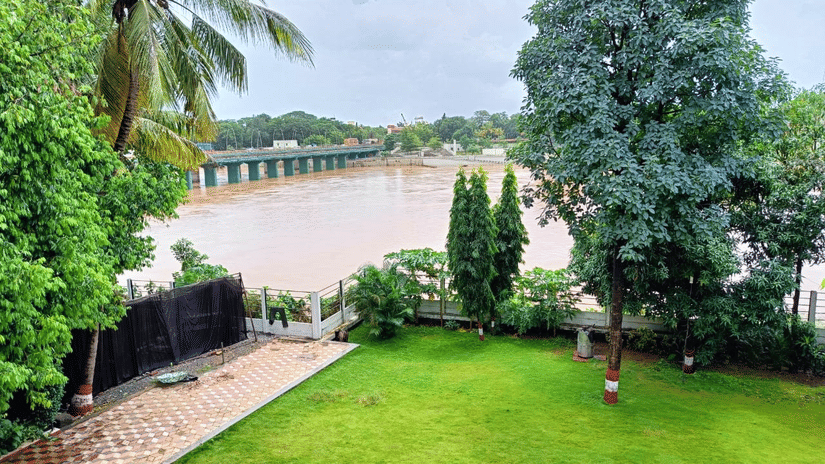 An overview of the Front Lawn area with trees surrounding the perimeter, overlooking the waterbody - VITS Kamats Resort, Silvassa