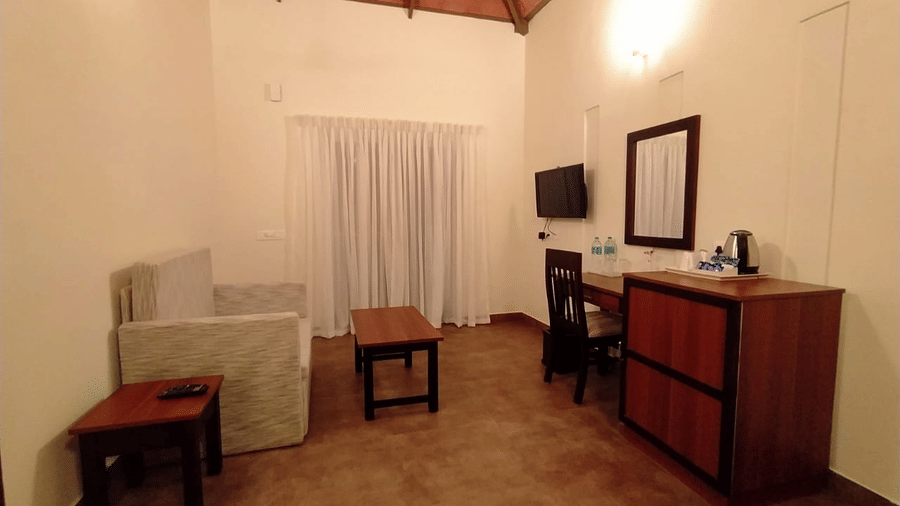 A view of a room shows the dresser and stool from a different angle.- Abad Brookside Lakkidi, Wayanad