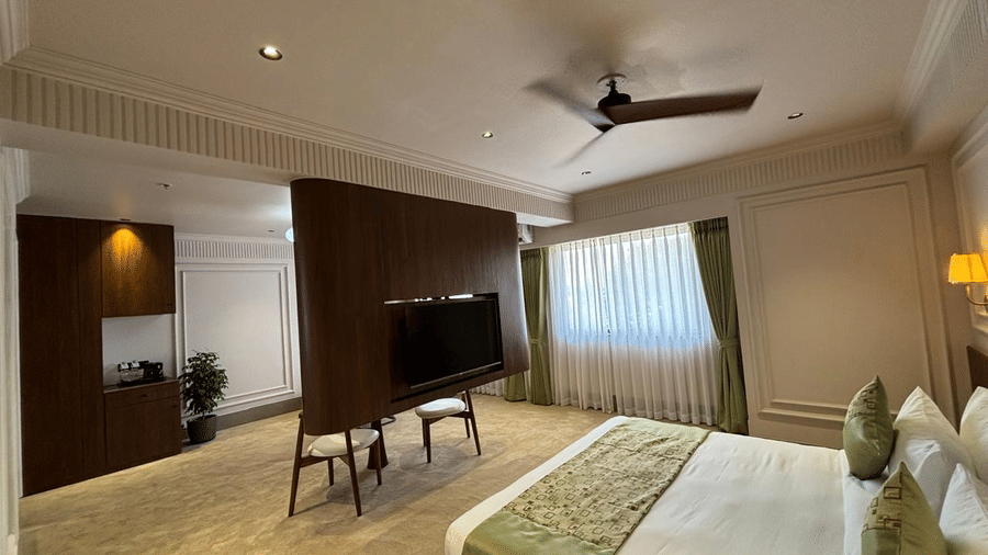 Spacious executive hotel suite at Biznotel by Pride Surat featuring a king bed, central TV partition, and modern furnishings.