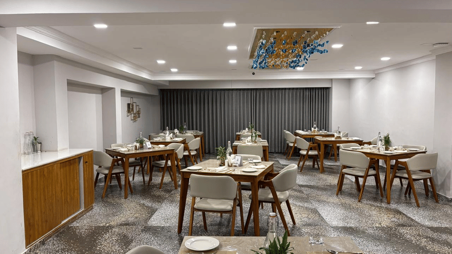 Spacious dining area at Biznotel by Pride Surat featuring stylish tables, plush chairs, and modern lighting.