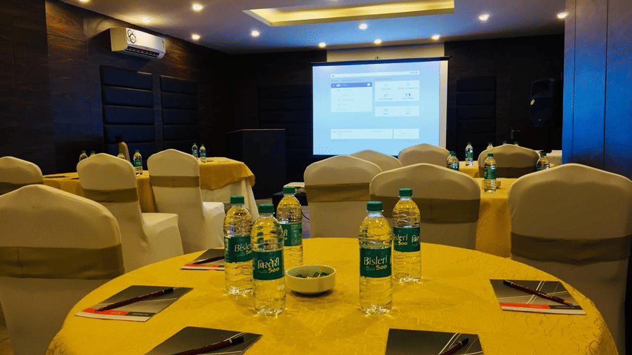 Image of a round table with water bottles and notepads placed on it at Amara Grand Baga, Goa.