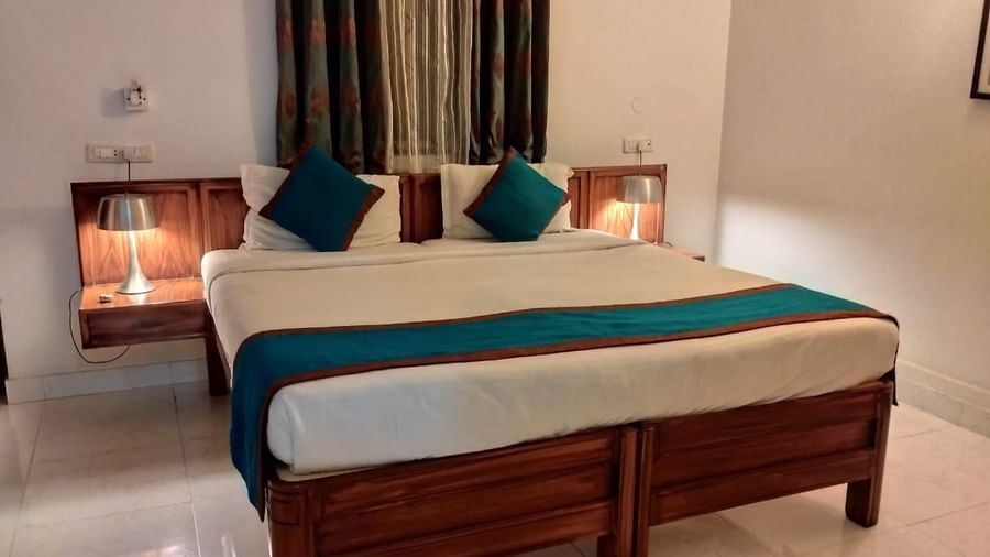 Cosy bedroom with double bed, pillows, and curtains at Fantasy Golf Resort.