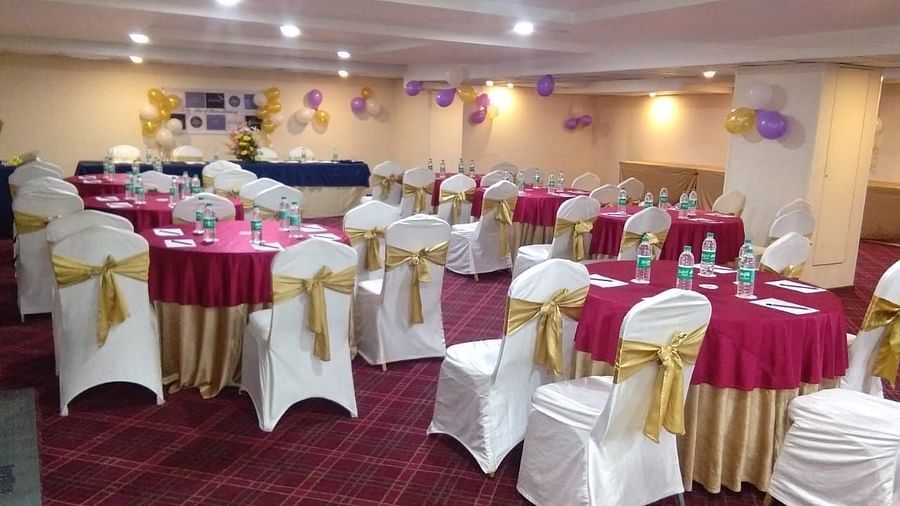 A banquet with seats arranged in party setup, portraying a sofa on the stage - Monarch Hotels