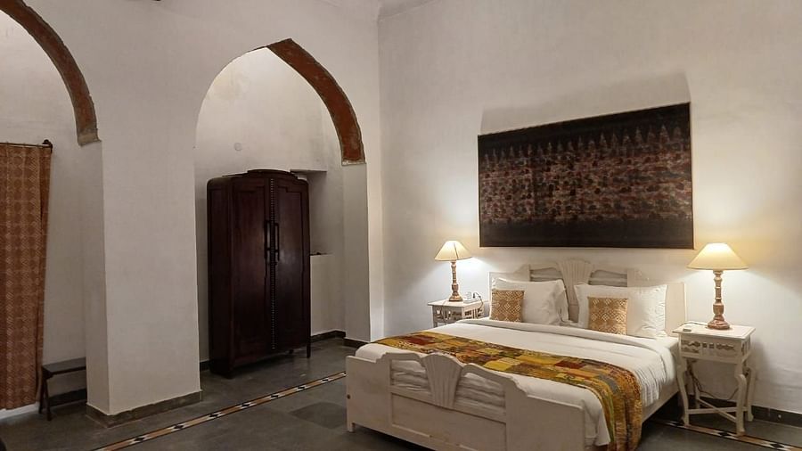 Guest room with arched doorways and period furniture showcasing traditional Rajasthani decor at Neemrana Fort-Palace.