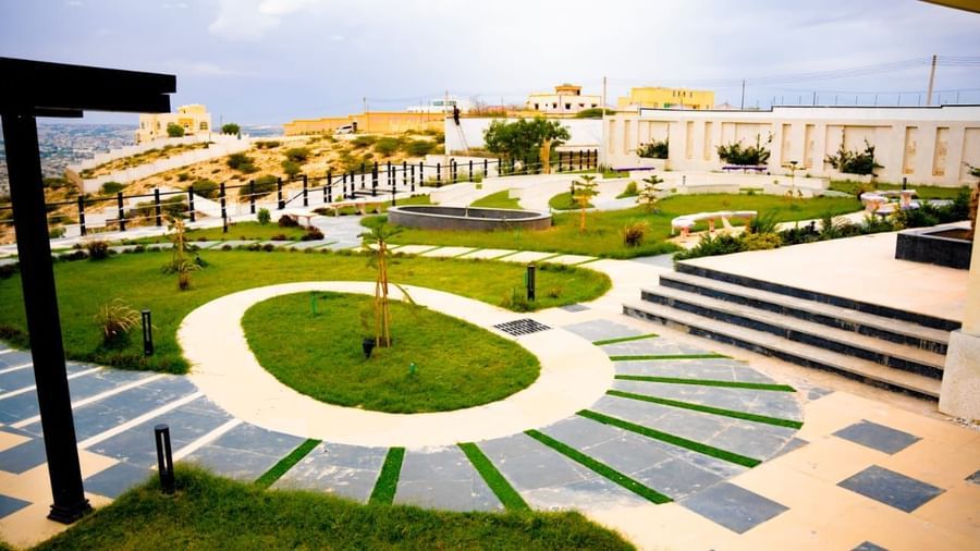 Outdoor view of a landscaped outdoor dining area with circular pathway design - Serene Sarovar Premiere Hargeisa