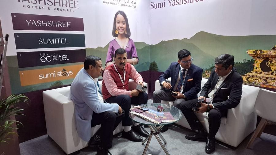 Team members engaged in a professional discussion at the Sumi Yashshree Hotels & Resorts booth, showcasing their hospitality brands and offerings.