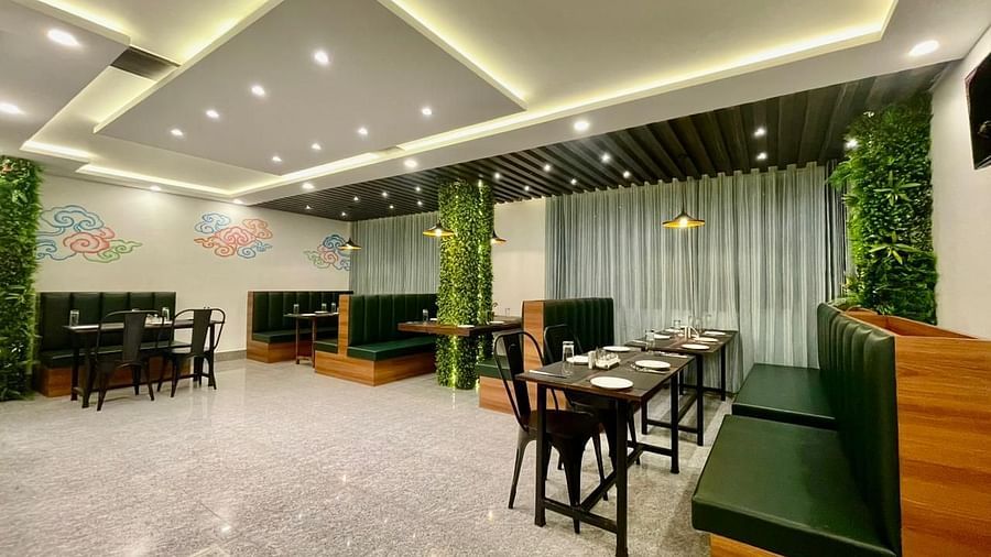 Dining tables and chairs placed in a well-lit enclosed space | Voyage The Royal Retreat, Gangtok