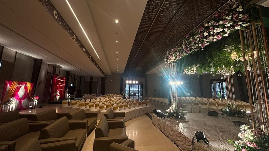 A wide-angle view of the hall featuring a combination of sofa seating and banquet chairs, with floral decorations throughout.