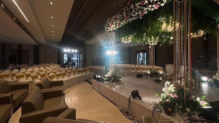 A luxurious indoor event space with elegant sofas, floral decorations, and a well-lit seating arrangement.