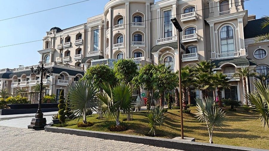 daytime view of the hotel facade with trees on both sides of a pathway leading to the hotel entrance - Sarovar Portico, Saharanpur