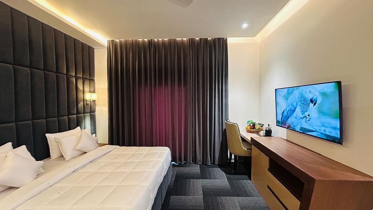 full view image of the executive room with a plush double bed and a wall mounted television at Eminence The Corbett