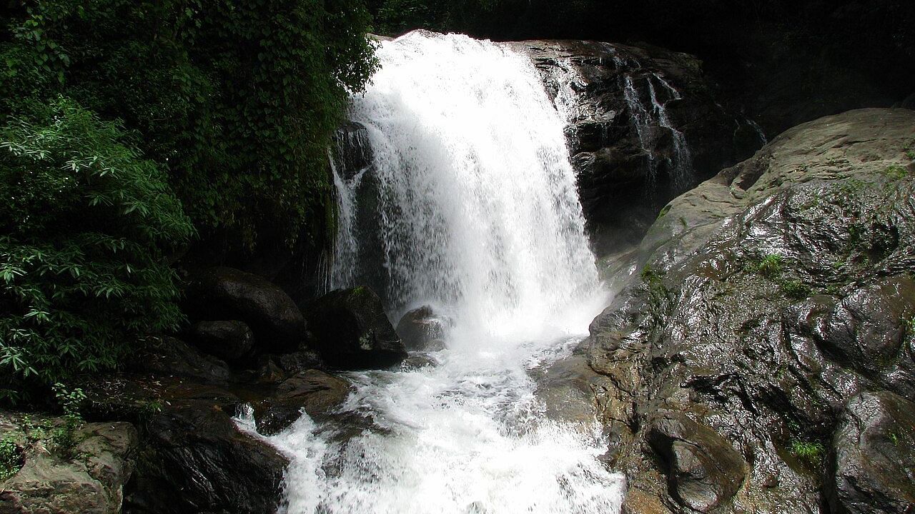 Lakkom Waterfalls with rocky stones flanking the sides and a powerful, fast-flowing cascade of water