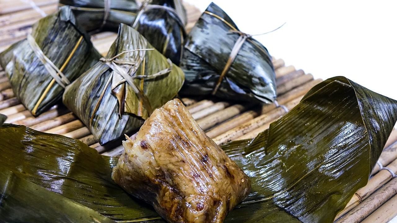Traditional dish wrapped in banana leaves, featuring steamed fish and rice.
