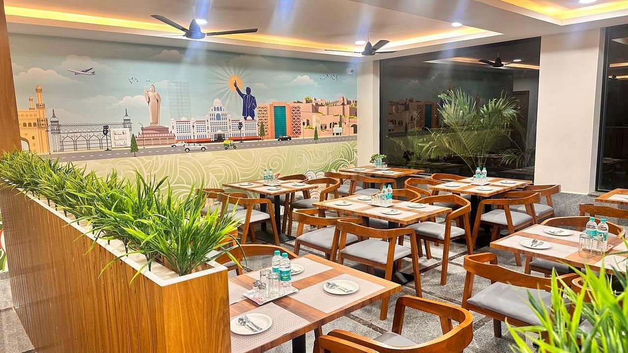 An image of a restaurant where many tables and chairs are arranged | Hotel Aerotel, Hyderabad