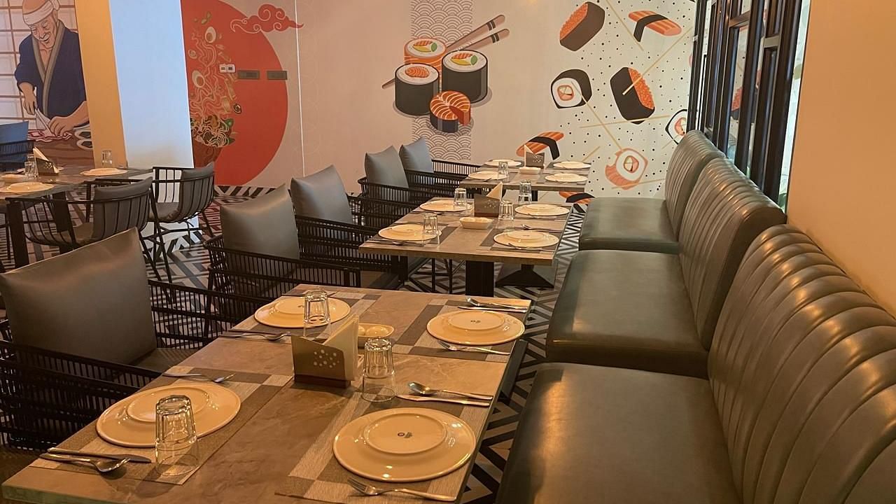 Dining area with booth seating and colourful wall art at Hotel Kyzen HiTech City – Your Zenly Stay
