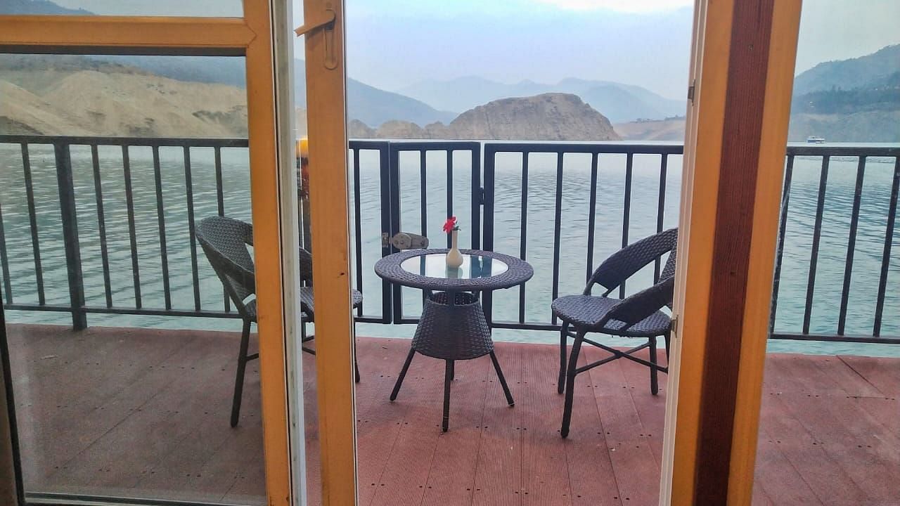 balcony area with a teapoy and chair at the floating huts in Le ROI Floating Huts Eco Rooms