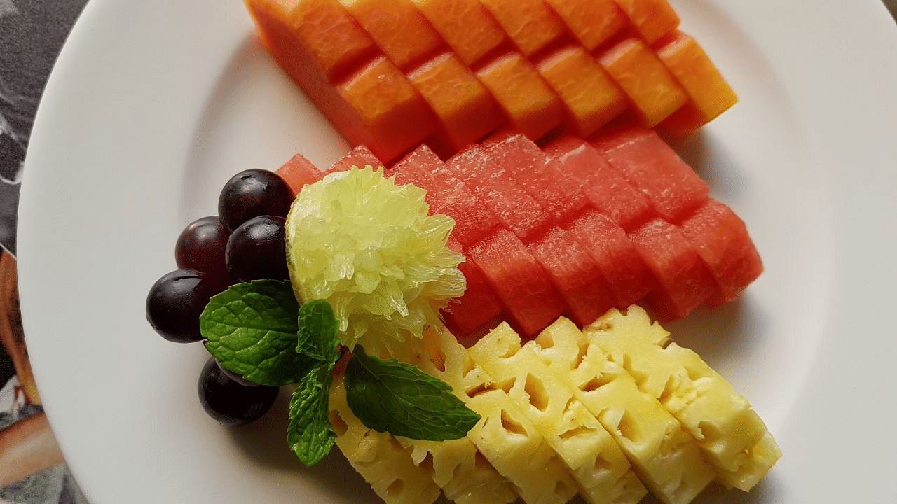 Various fruits cut in a pattern arranged on a plate