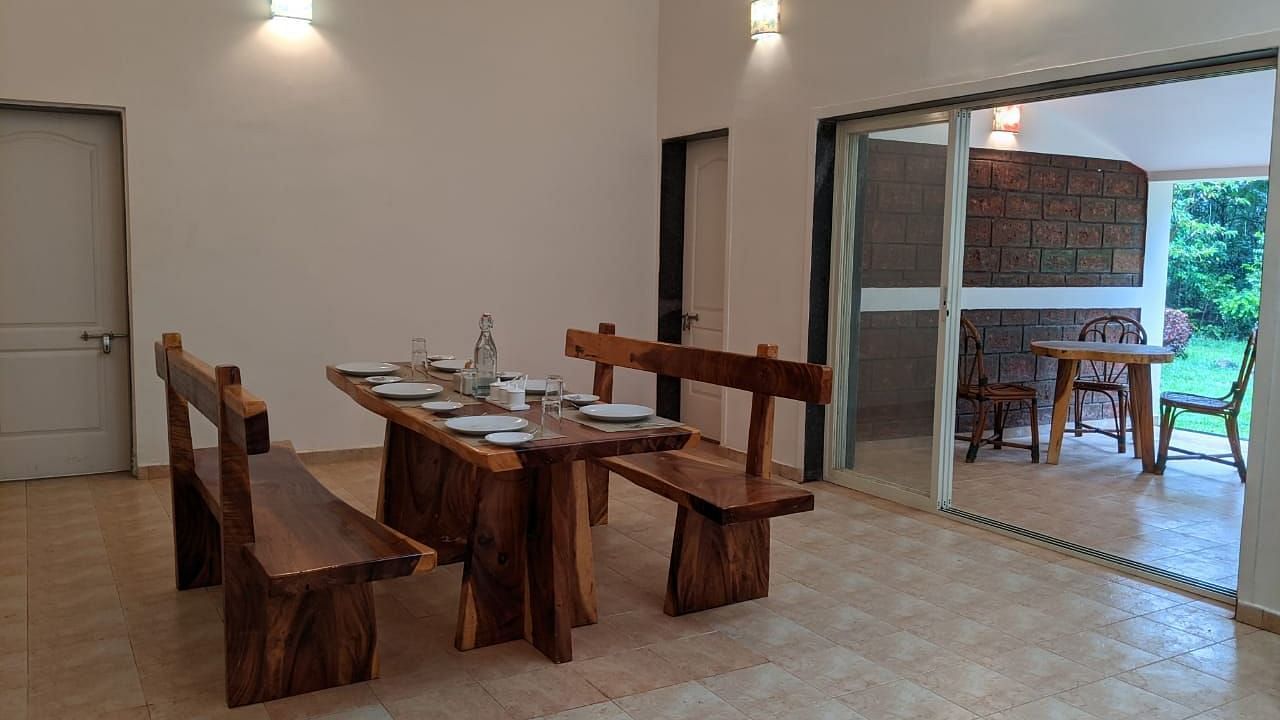 Indoor dining space with rustic wooden furniture and bright lighting at The Conservancy Bungalow.