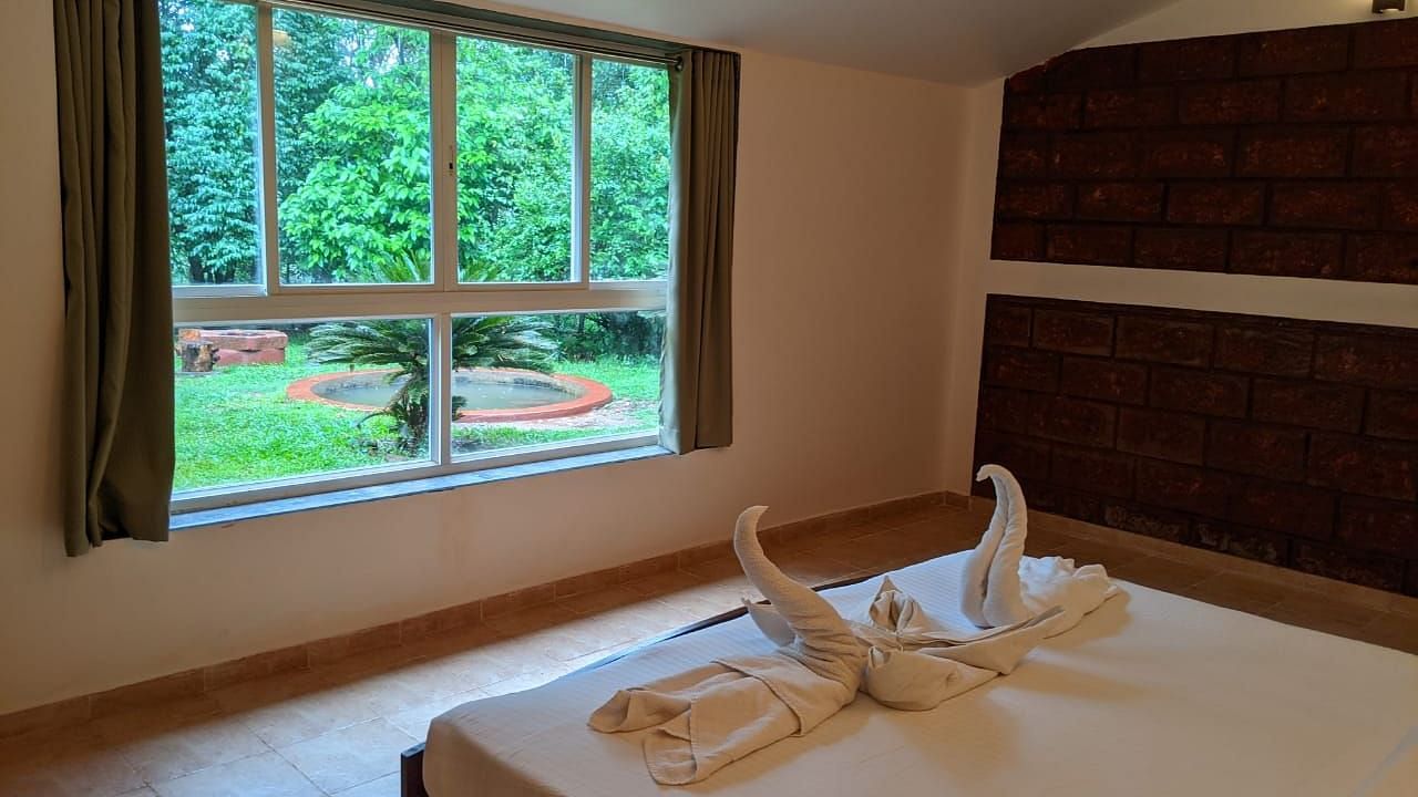  A bedroom with a scenic garden view through a large window at The Conservancy Bungalow.