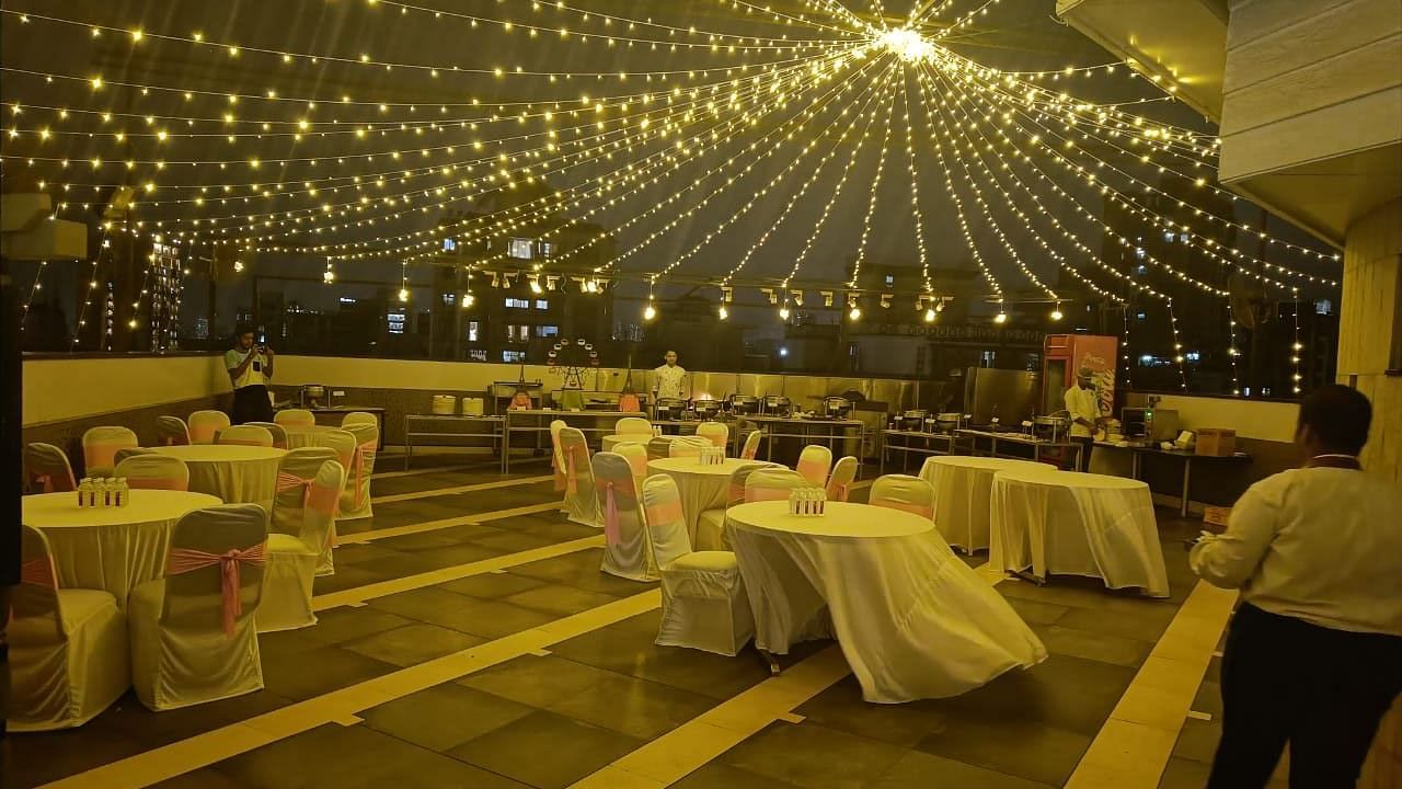 Image of an event space at night with chairs and tables and lights hanging from above at The Oriental Residency