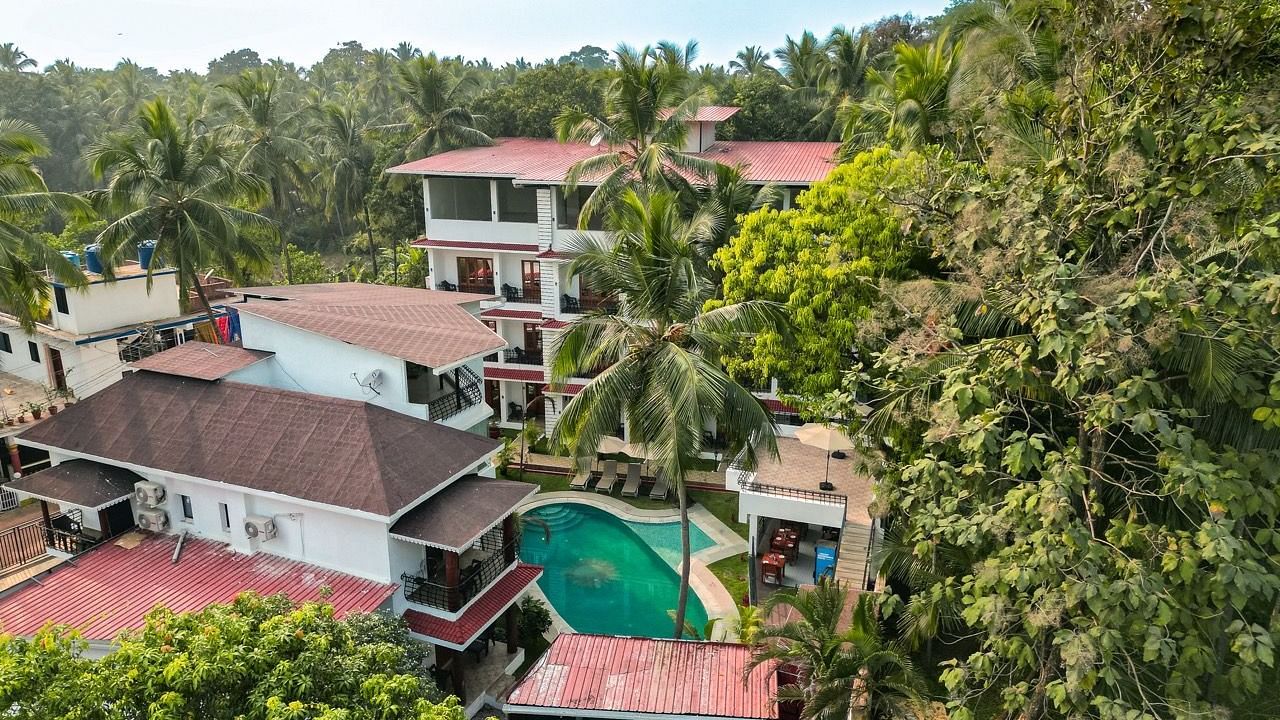 An aerial view of  The Verda de Miranda Resort with a pool nestled among palm trees.