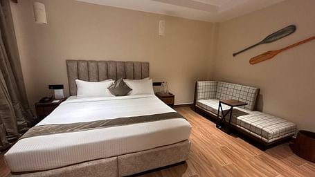 Bright bedroom with a plush king-sized bed, wooden furniture, and a contemporary design - Arina Island Resort, Swaraj Dweep