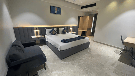 Suite with cosy seating area and king size bed at Hotel Kyzen HiTech City – Your Zenly Stay
