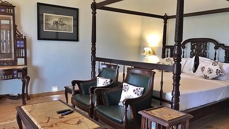 A traditional hotel bedroom with a four-poster bed and a sitting area - Khas Bagh, Jaipur.