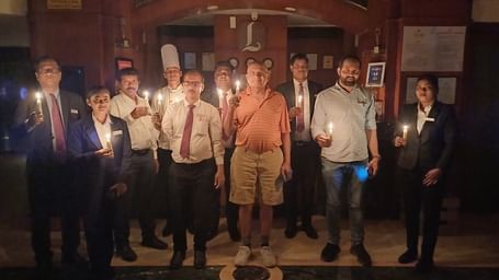 A large group of people holding  candles in a dark atmosphere.