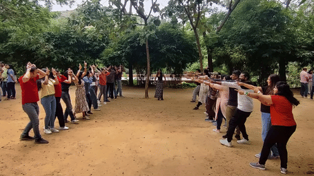 Group of participants standing in two rows during an outdoor team-building activity in a wooded area | RD's Nature Retreat