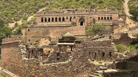 An overview of Bhangarh Fort with massive walls stretching across a hilltop - Utsav Camp Sariska.