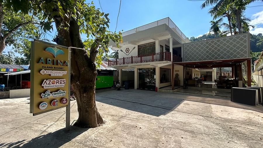 Image of the front yard at the resort during a sunny day featuring the facade  and trees all around | Arina Island Resort