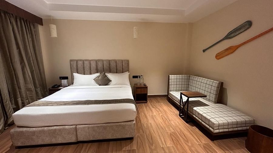 Elegant bedroom with a king-sized bed, sofa, and neutral-toned décor- Arina Island Resort, Swaraj Dweep