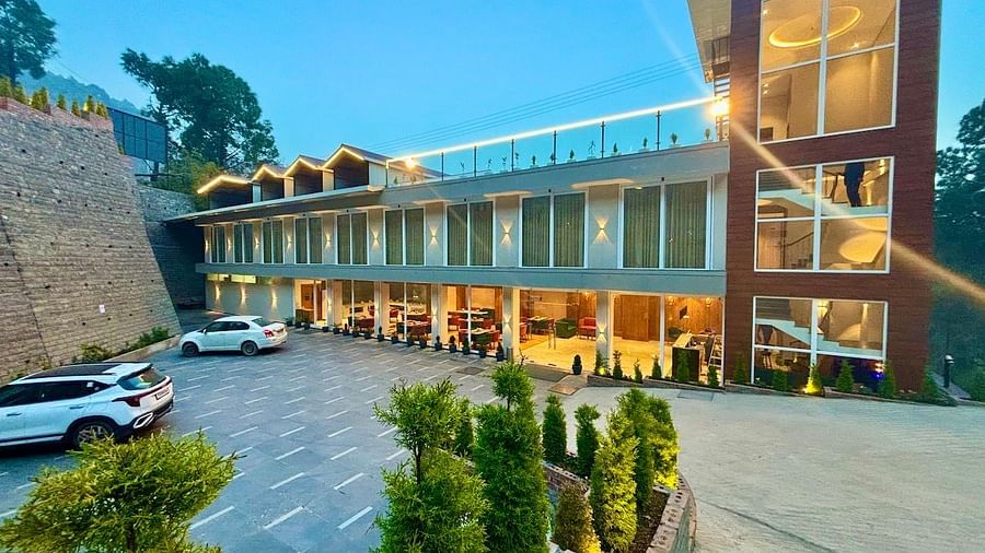 Exterior view of the ARNISA Boutique Hotel building with glass facade and neatly landscaped driveway