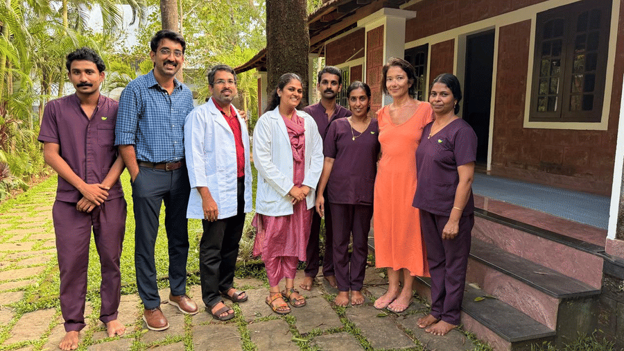 A group of people  along with doctors standing outside of Ayur villas and posing at Ayur On The Beach Nattika.