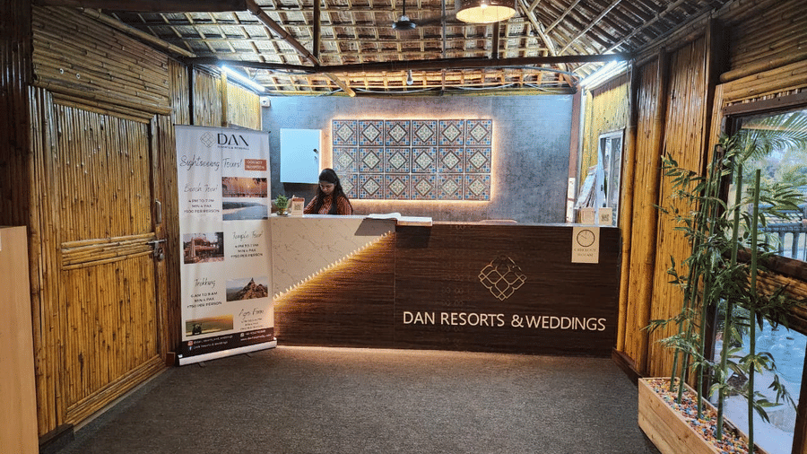 Modern reception desk with bamboo-style walls and back lit branding - DAN Resorts & Weddings, Palghar