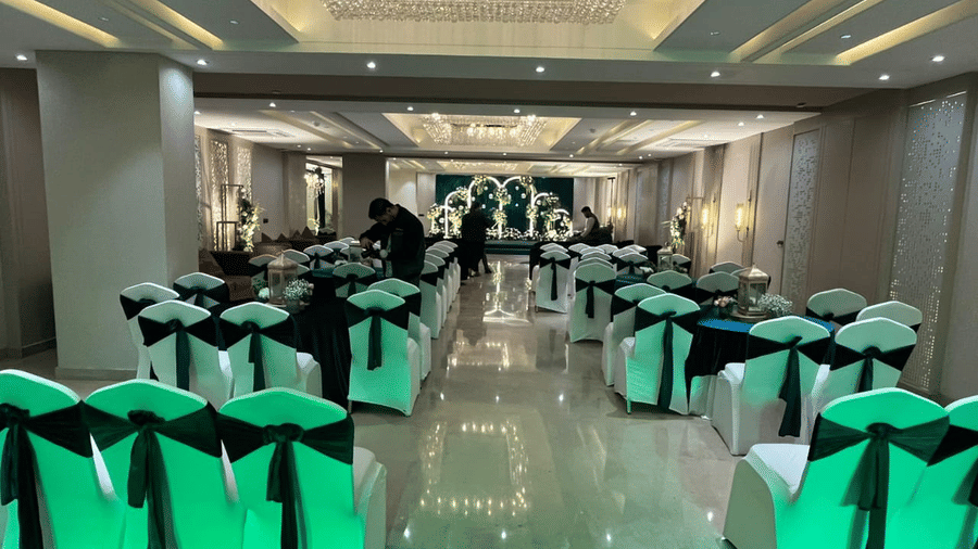 A wide-angle shot of the Crystal Hall with chairs facing towards the stage at Hotel 91 Privé, Gurugram.