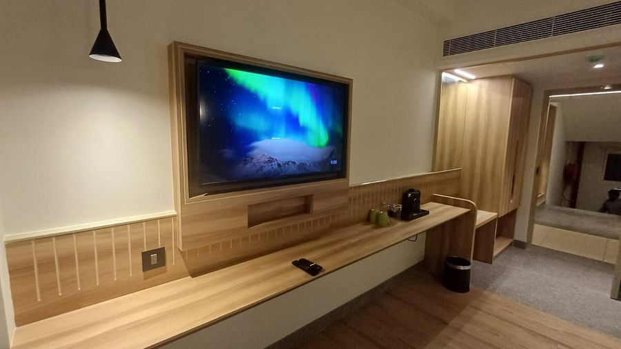 Image of a living room with television and wooden floring at Hotel Raai, Hosur.