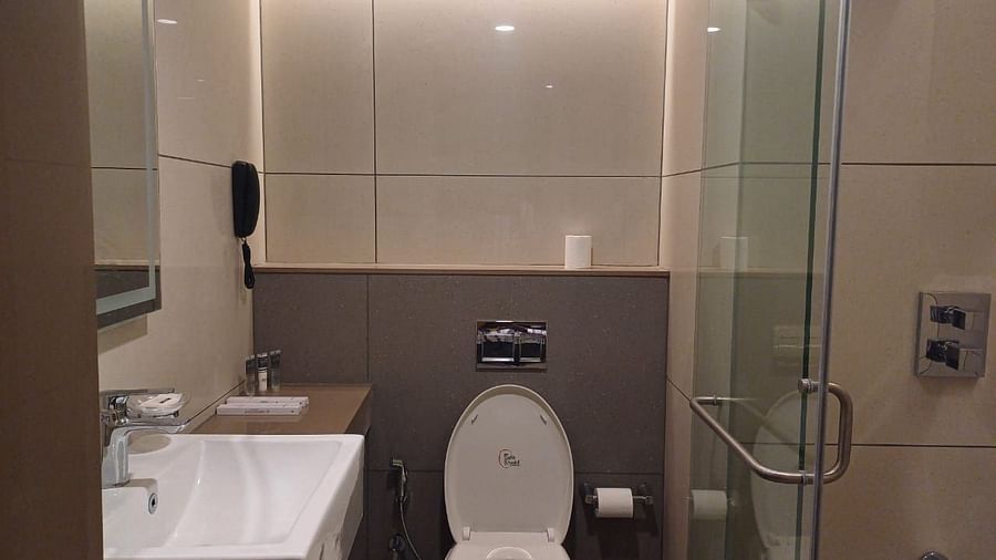Image of a washroom with seperate shower space and modern amenities at Hotel Raai, Hosur.