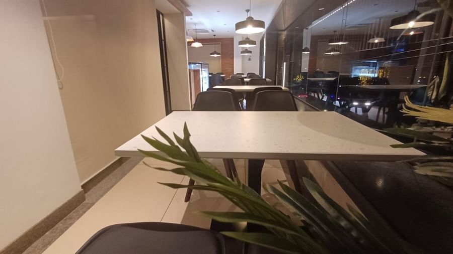 The Brew House at Hotel Paai, Hosur featuring seat arrangement in L shaped near the glass wall. 