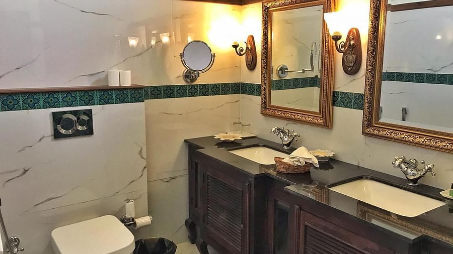 A classic hotel bathroom with twin sinks, wooden vanity, and decorative mirrors - Khas Bagh, Jaipur.